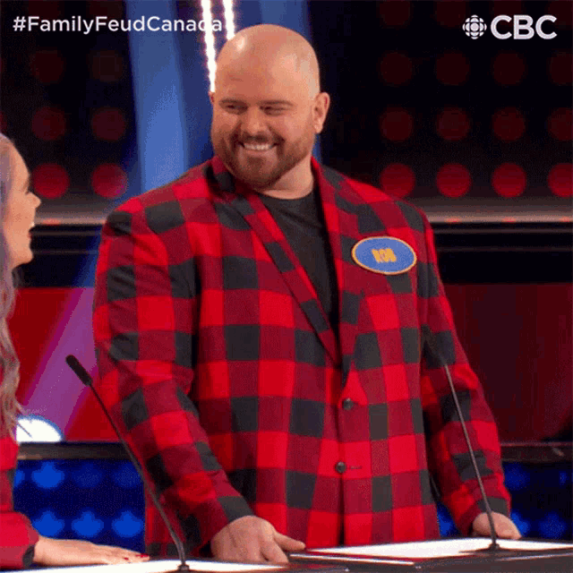 a man wearing a plaid jacket with a name tag that says chris