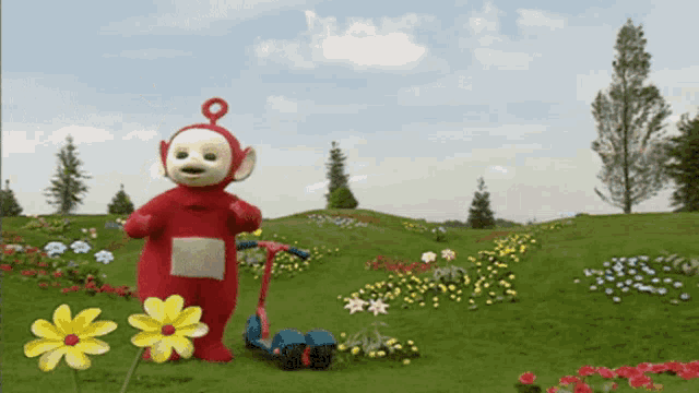 a teletubbies character in a field with flowers