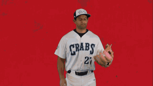 a baseball player for the crabs is holding a baseball