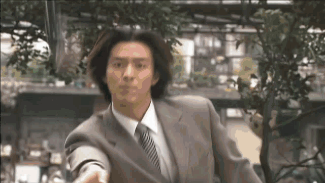 a man in a suit and tie is throwing a ball