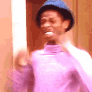a man wearing a blue hat and a purple sweater