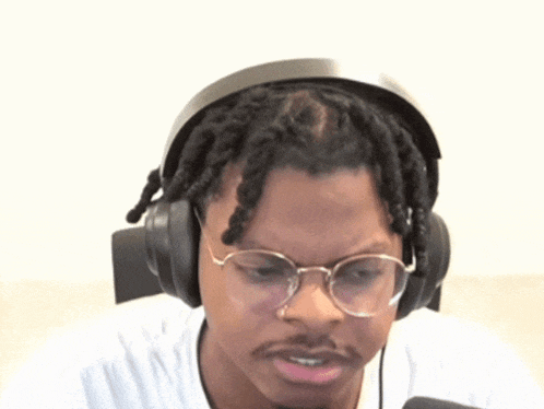 a man with dreadlocks wearing headphones and glasses