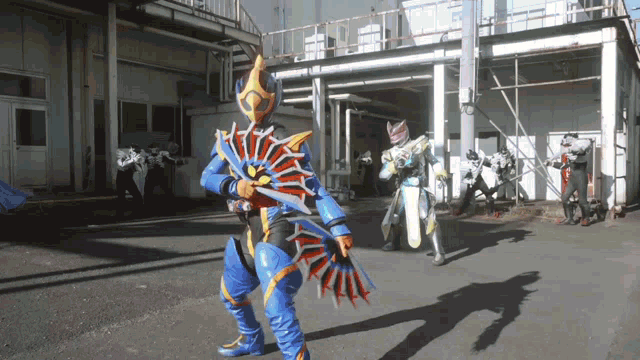 a man in a blue and yellow costume is holding a sword