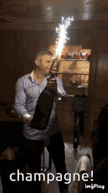 a man is holding a bottle of champagne with sparklers coming out of it