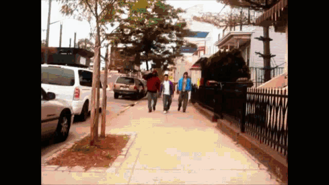 a group of people walking down a sidewalk with a white suv parked on the side
