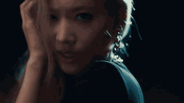 a close up of a woman 's face with her hand on her ear