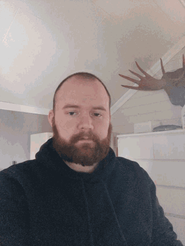 a man with a beard is looking down at something