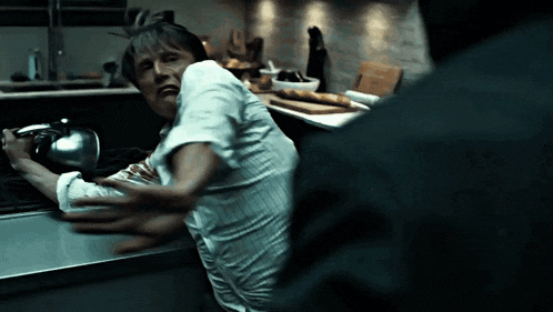 a man in a white shirt is being attacked by a man in a black jacket