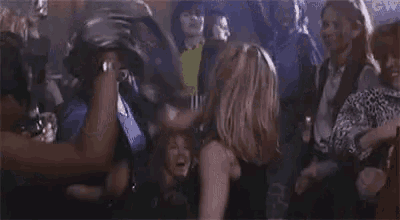 a group of people are dancing in a club while drinking beer .