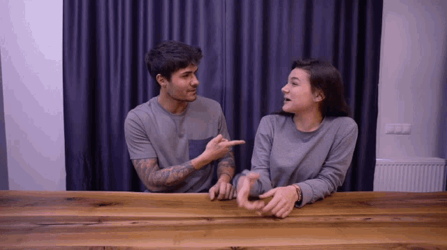 a man and a woman sitting at a table talking