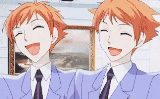two anime characters are laughing together in front of a picture .