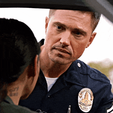 a police officer with a badge that says ' police of los angeles ' on it