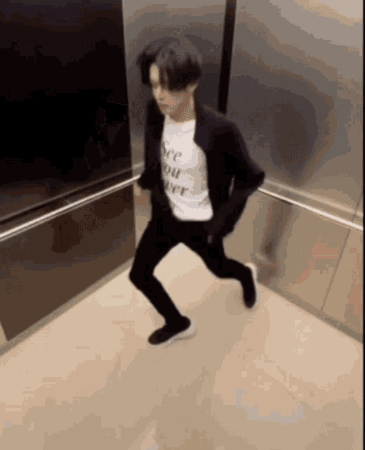 a man in an elevator wearing a shirt that says " see you later "