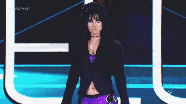 a woman stands in front of a sign that says wwe