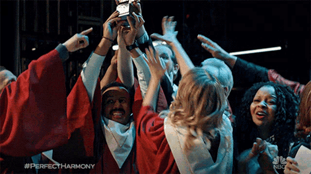 a group of people holding up a trophy with perfectharmony written in the corner
