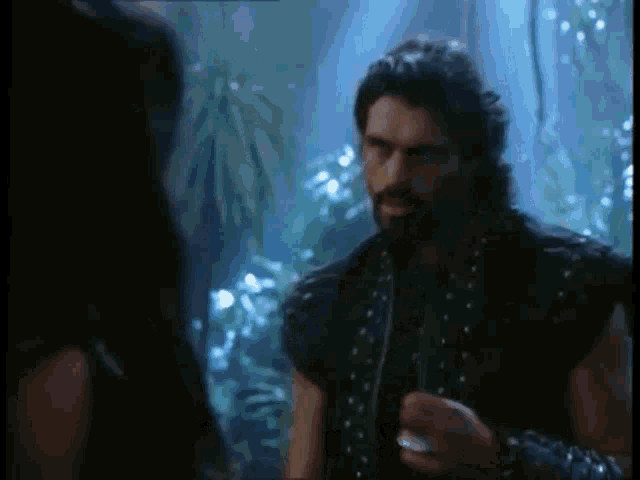 a man with a beard is standing next to a woman .