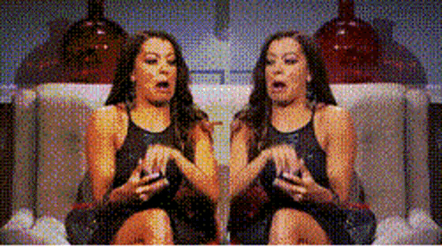 two women are sitting next to each other on a couch with their mouths open
