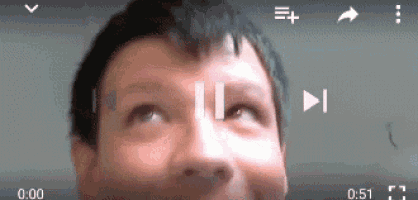a close up of a man 's face with a play button on the bottom