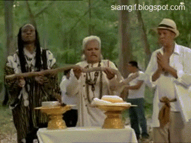a group of people standing around a table with a siamgif.blogspot.com watermark in the corner