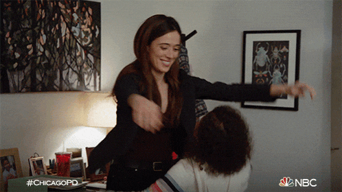 a woman in a black jacket is hugging another woman in a room with #chicagopd on the bottom