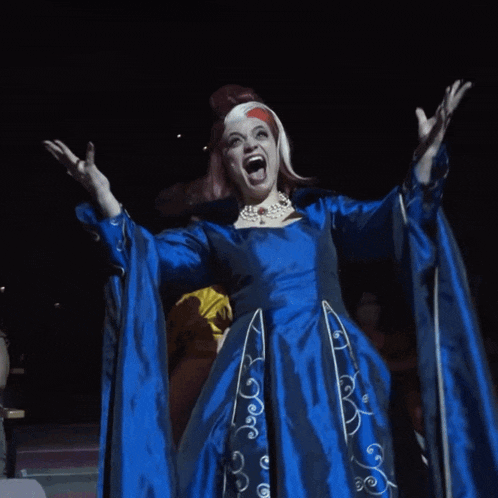 a woman in a blue dress is screaming while another woman in a yellow dress looks on