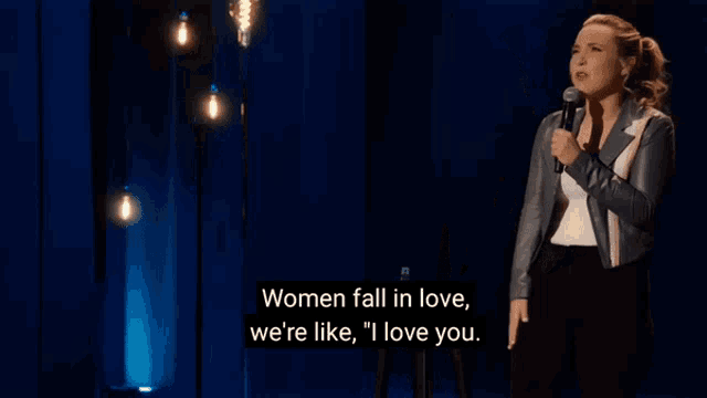 a woman singing into a microphone with the words women fall in love