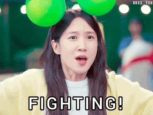 a girl with a green balloon on her head says fighting