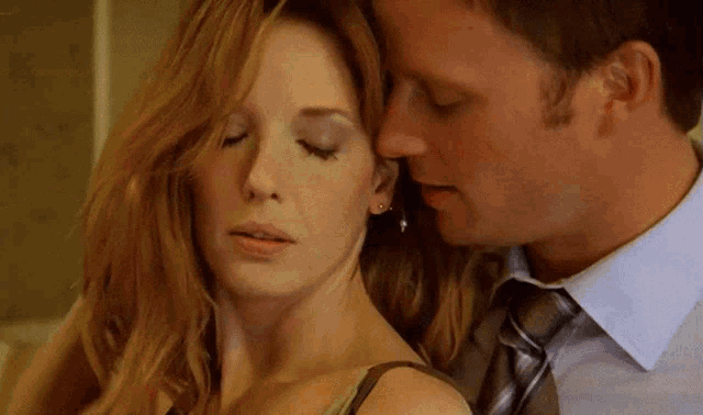 a man kisses a woman on the neck in a close up