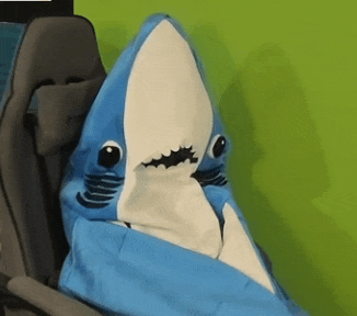 a blue and white stuffed shark is wrapped in a chair