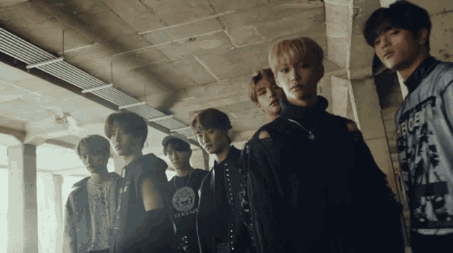 a group of young men standing next to each other with one wearing a versace t-shirt