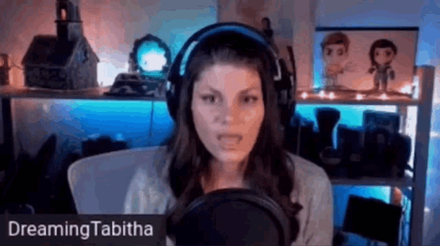 a woman wearing headphones is talking into a microphone in a room .
