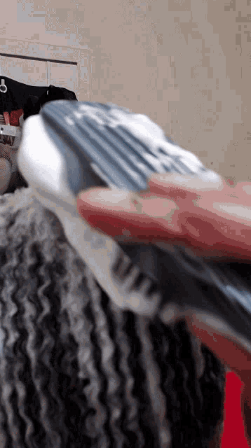 a person is brushing their hair with a brush that has a foam on it