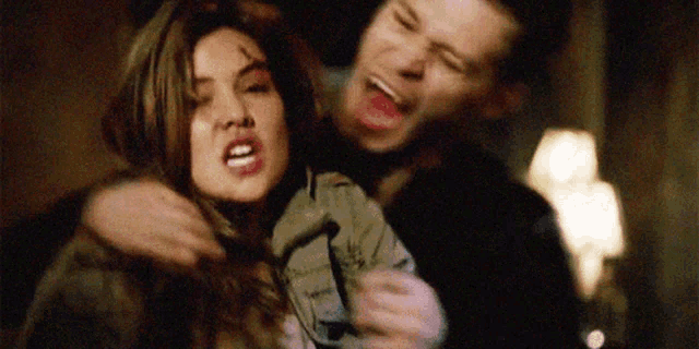 a man and a woman are standing next to each other and the woman is screaming .