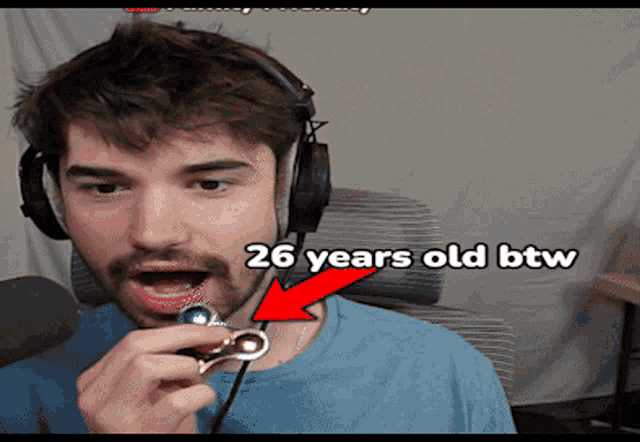 a man wearing headphones is holding a small object in his mouth and the words 26 years old btw are on the bottom