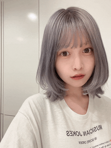 a girl with gray hair is wearing a white t-shirt that says 23kol иаiigum