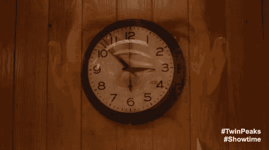a clock on a wooden wall with the words #twinpeaks #showtime below it