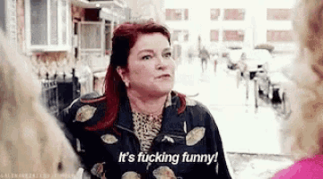 a woman is standing on a street talking to another woman and saying `` it 's fucking funny ! ''