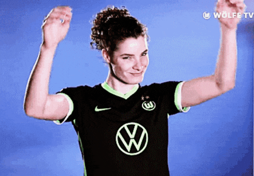 a woman wearing a black shirt with a green w on it