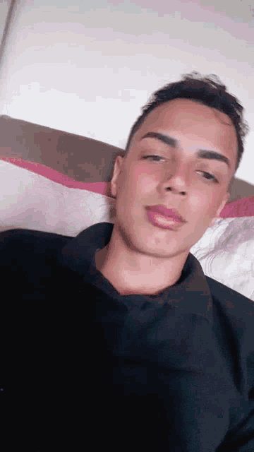 a young man is laying on a couch and taking a selfie