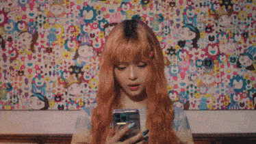 a woman with red hair is looking at her phone