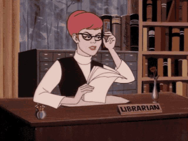 a librarian sits at a desk with a book in her hand