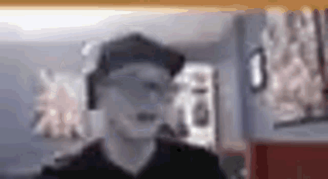 a man wearing a hat and headphones is standing in a room .