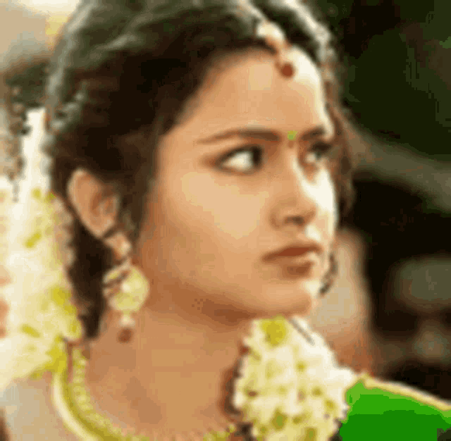 a close up of a woman 's face with flowers in her hair and earrings .