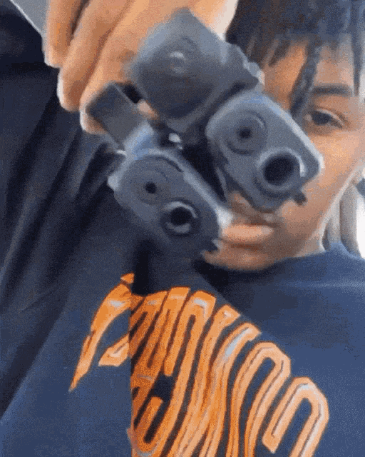 a person is holding two guns in front of their face