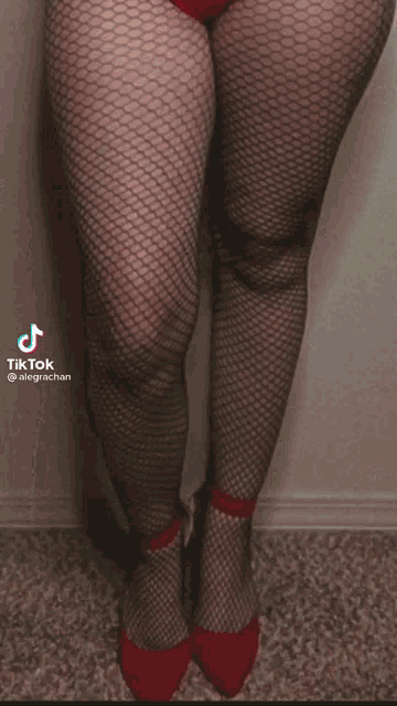 a woman in a red leotard and fishnet stockings has a tiktok icon above her