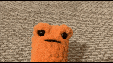 a close up of a stuffed animal sitting on a carpet .