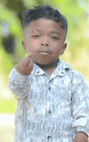 a young boy in a white shirt is making a middle finger gesture
