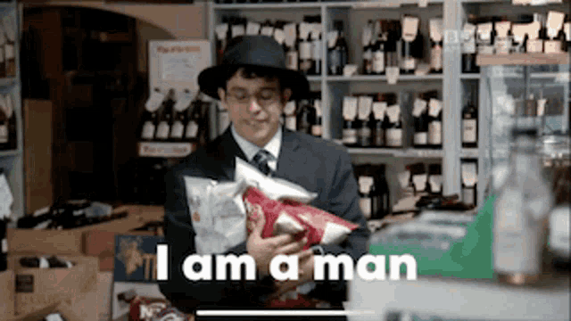 a man in a hat is holding a bag of chips and the words i am a man are above him