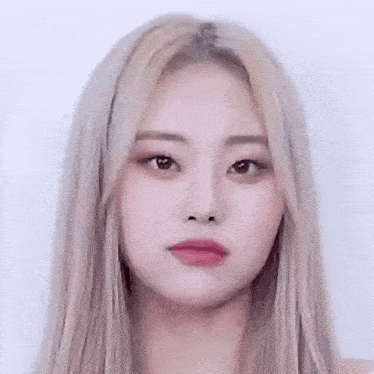 a woman with long blonde hair is making a funny face .
