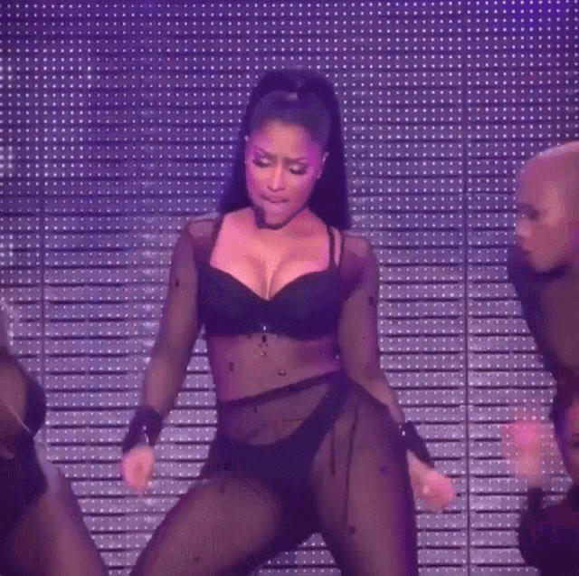 a woman in lingerie is dancing on a stage in front of a purple background